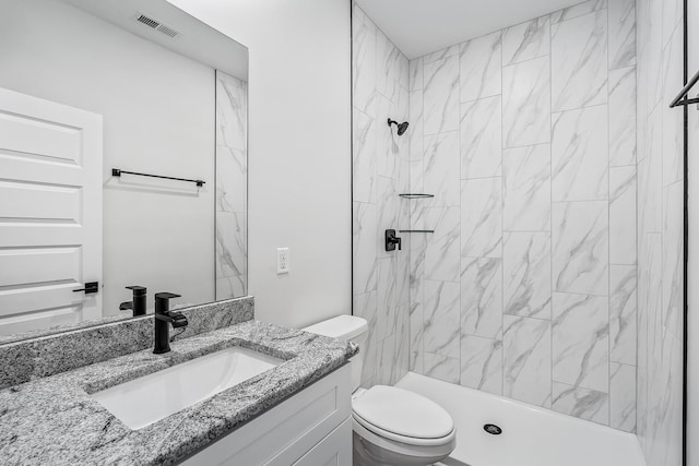 bathroom featuring toilet, a stall shower, visible vents, and vanity