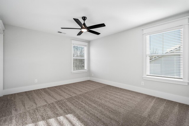 spare room with baseboards, visible vents, and carpet flooring