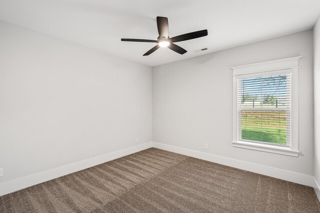 carpeted empty room featuring visible vents, ceiling fan, and baseboards