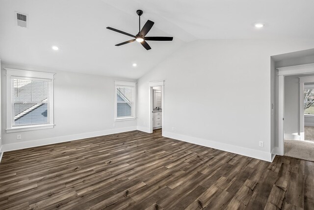 unfurnished living room with dark wood-type flooring, lofted ceiling, visible vents, and plenty of natural light