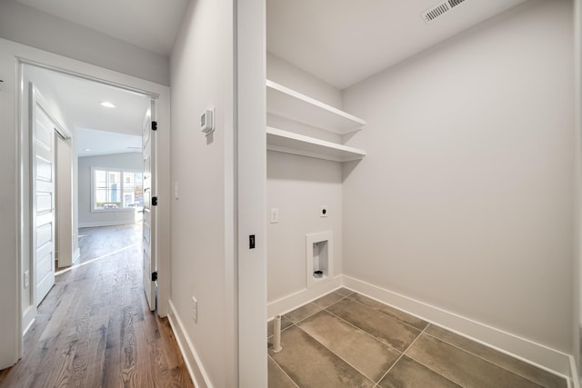 laundry area with hookup for an electric dryer, baseboards, visible vents, laundry area, and wood finished floors