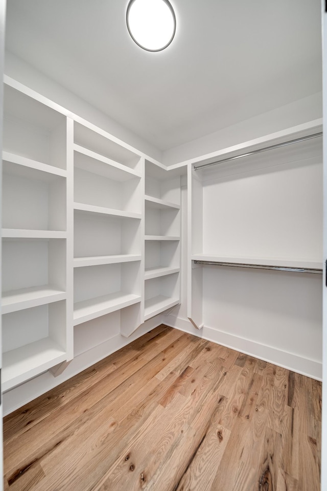 walk in closet with wood finished floors