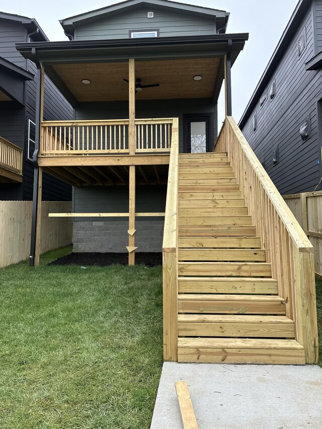 exterior space with stairs, fence, and a lawn
