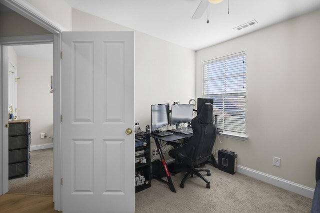 office space with light carpet, visible vents, and baseboards