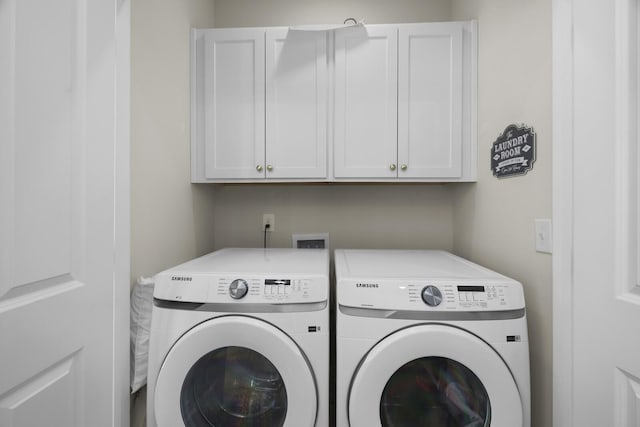 laundry area featuring separate washer and dryer and cabinet space