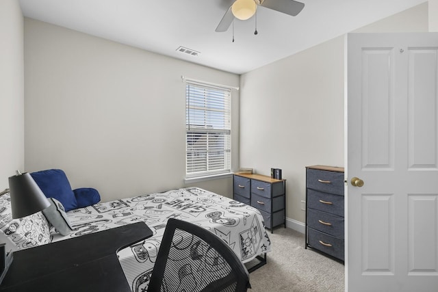 bedroom with light carpet, ceiling fan, visible vents, and baseboards