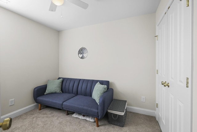 sitting room with a ceiling fan, light colored carpet, and baseboards