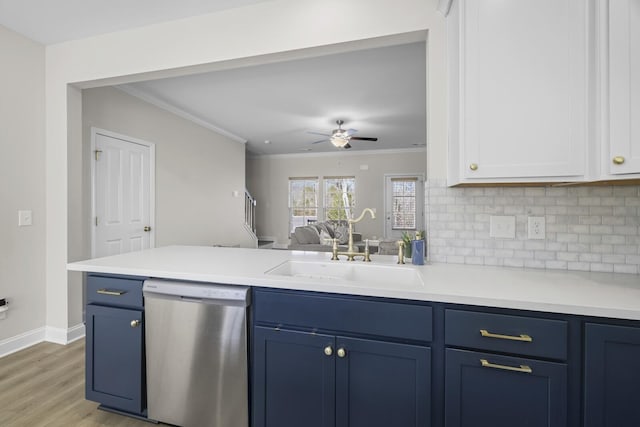 kitchen with light countertops, stainless steel dishwasher, blue cabinetry, and a sink