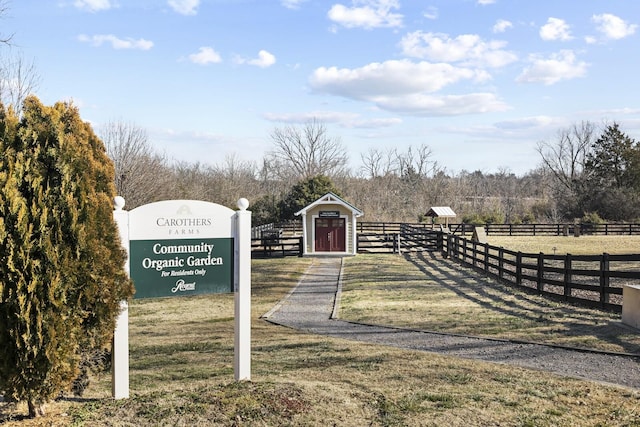 exterior space featuring a rural view, a gate, fence, and a yard