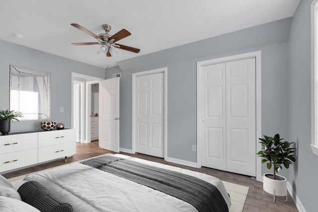 bedroom with multiple closets, light wood-style floors, baseboards, and a ceiling fan