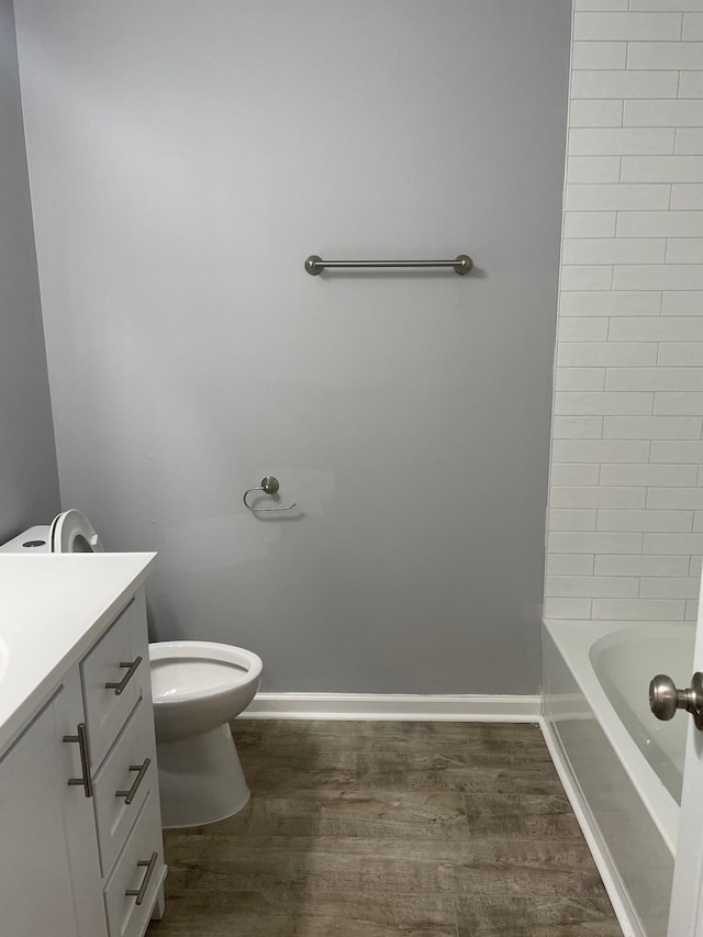 full bathroom featuring baseboards, vanity, toilet, and wood finished floors