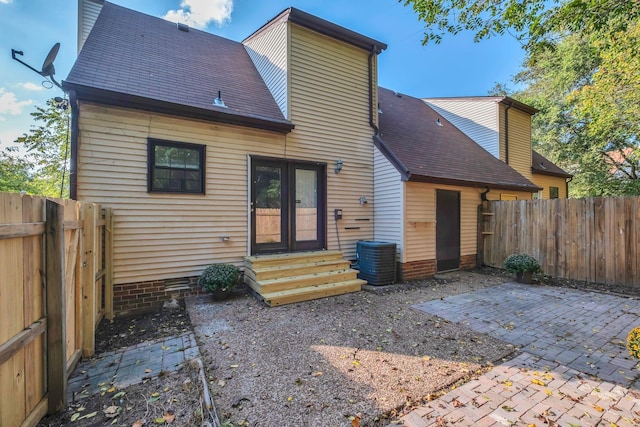 rear view of house featuring entry steps, a patio area, a shingled roof, and fence