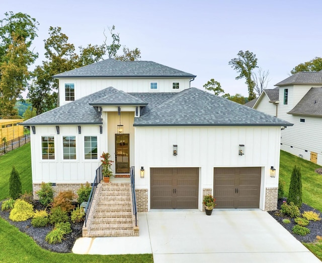 view of front facade featuring board and batten siding, roof with shingles, driveway, and a garage