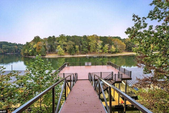 view of dock with a water view and a view of trees