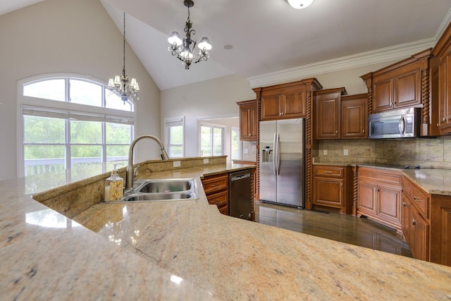 kitchen with brown cabinetry, light stone countertops, black appliances, pendant lighting, and a sink