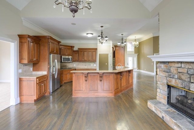 kitchen with stainless steel appliances, brown cabinets, light countertops, and a chandelier