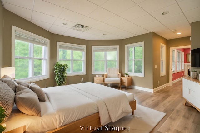 bedroom with light wood finished floors, recessed lighting, visible vents, a drop ceiling, and baseboards