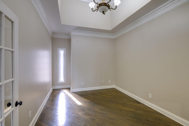 empty room with dark wood-style floors, a notable chandelier, crown molding, visible vents, and baseboards