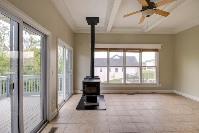 interior space with a wood stove, a healthy amount of sunlight, baseboards, and beam ceiling