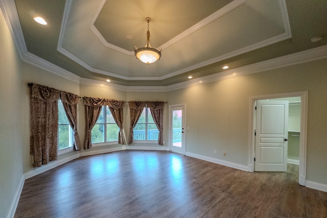 unfurnished room with crown molding, dark wood-type flooring, a raised ceiling, and baseboards