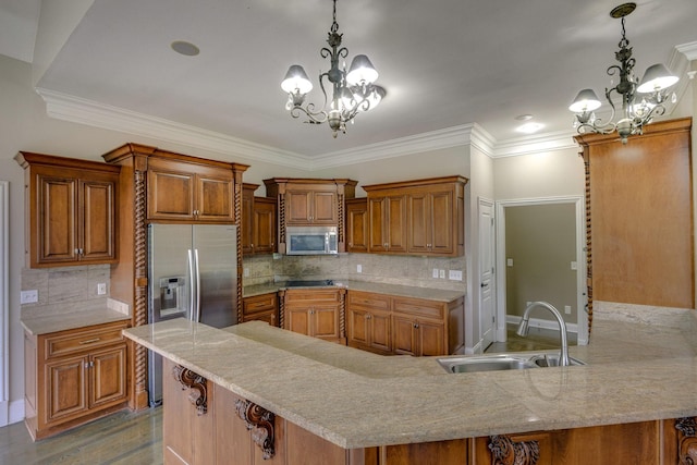 kitchen featuring a notable chandelier, pendant lighting, stainless steel appliances, and a sink