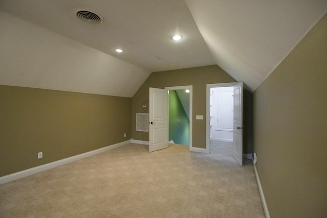 additional living space with lofted ceiling, visible vents, light carpet, and baseboards