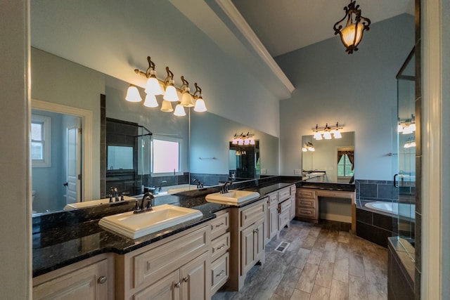 full bathroom with a garden tub, double vanity, a sink, a shower stall, and wood finished floors