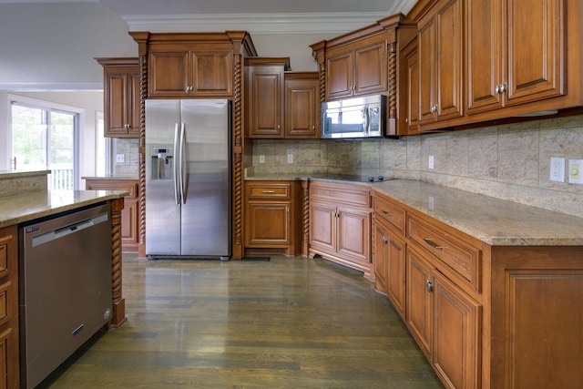 kitchen featuring brown cabinets, ornamental molding, stainless steel appliances, and light stone counters