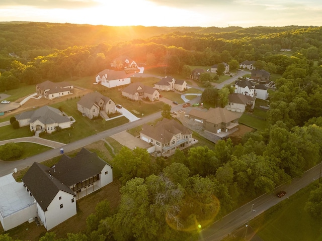 aerial view at dusk with a residential view and a wooded view