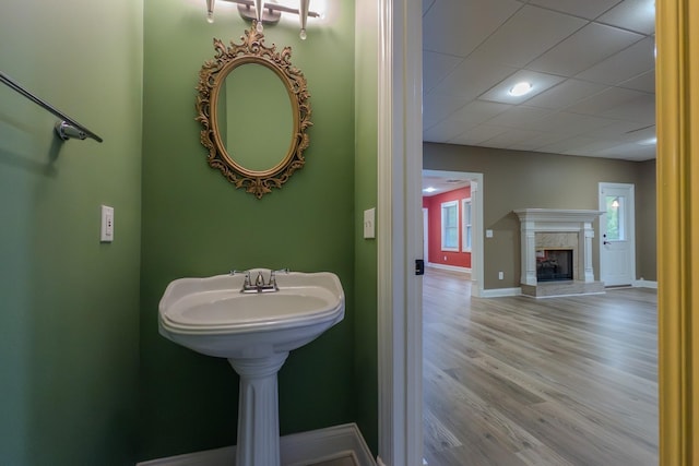 bathroom featuring a wealth of natural light, a high end fireplace, baseboards, and wood finished floors