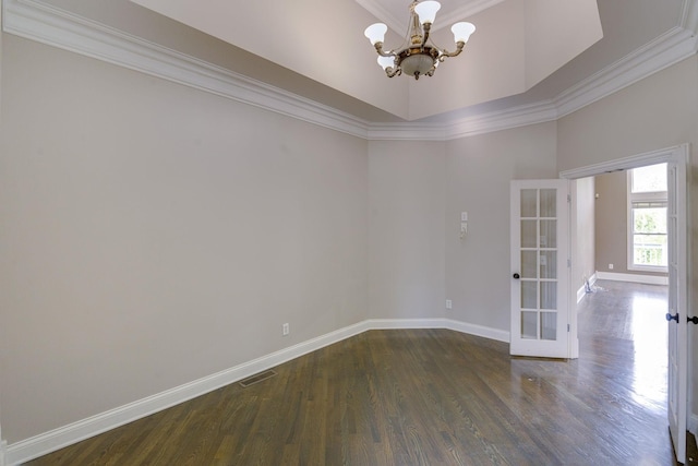 unfurnished room with baseboards, ornamental molding, dark wood-type flooring, an inviting chandelier, and french doors