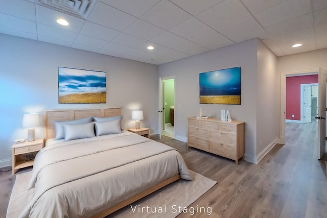 bedroom with recessed lighting, wood finished floors, and baseboards