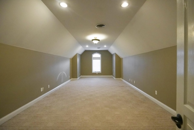 additional living space featuring recessed lighting, light carpet, visible vents, baseboards, and vaulted ceiling