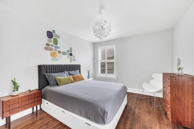 bedroom with dark wood-type flooring and baseboards