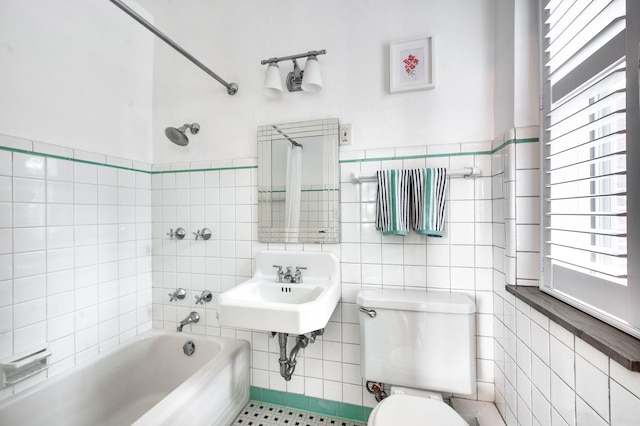 full bathroom with toilet, shower / tub combination, tile walls, and a wealth of natural light