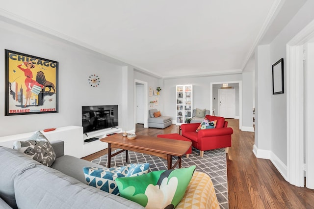 living area with baseboards, dark wood finished floors, and crown molding