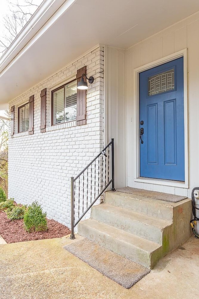 doorway to property featuring brick siding