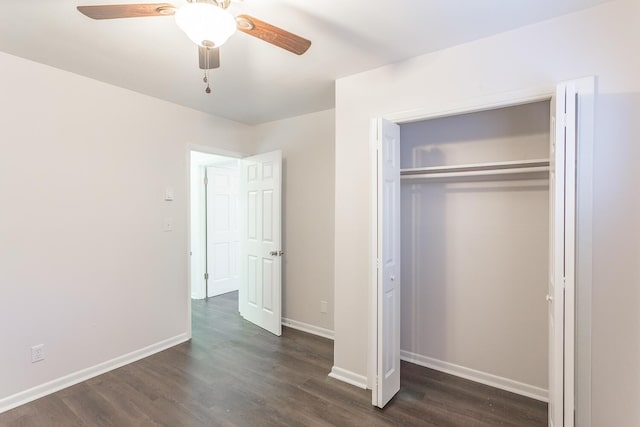 unfurnished bedroom featuring dark wood-type flooring, a closet, and baseboards