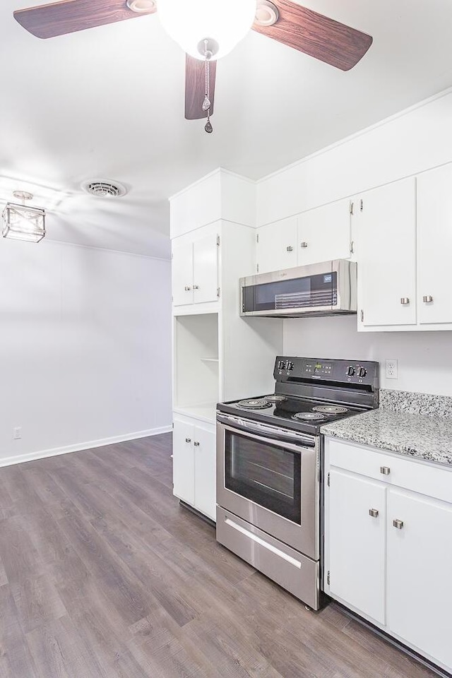 kitchen with visible vents, white cabinets, wood finished floors, range hood, and stainless steel range with electric cooktop