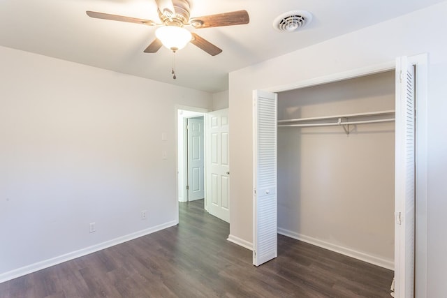 unfurnished bedroom with a closet, visible vents, dark wood-type flooring, a ceiling fan, and baseboards