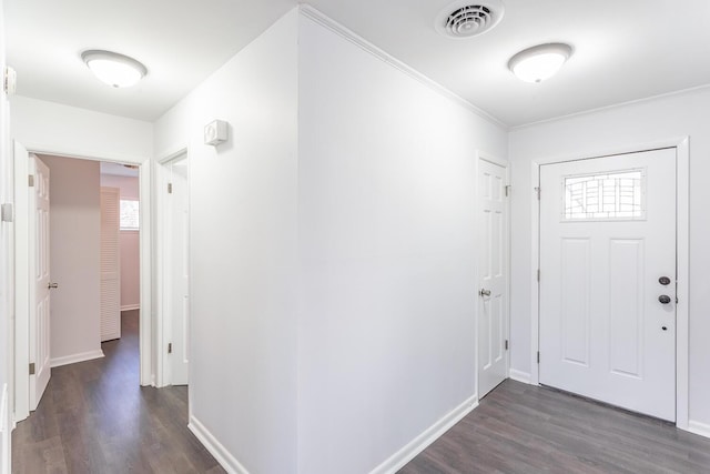 foyer entrance featuring baseboards, crown molding, visible vents, and dark wood-type flooring