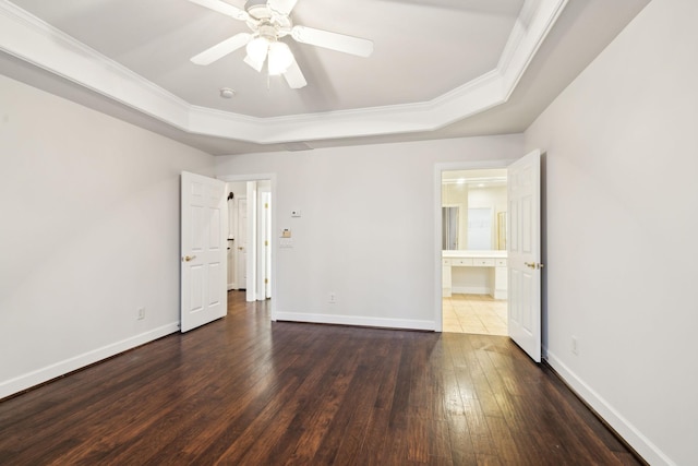 unfurnished bedroom featuring dark wood-style floors, baseboards, and a tray ceiling