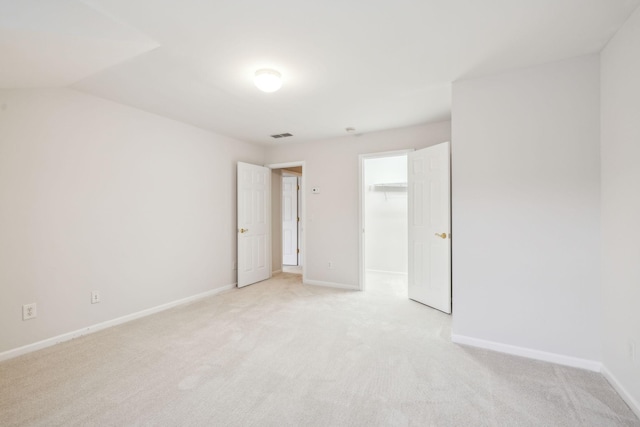 spare room with visible vents, baseboards, and light colored carpet