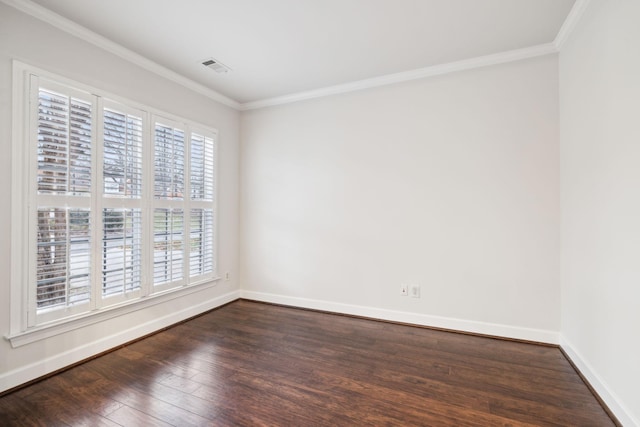 unfurnished room with dark wood-type flooring, visible vents, crown molding, and baseboards