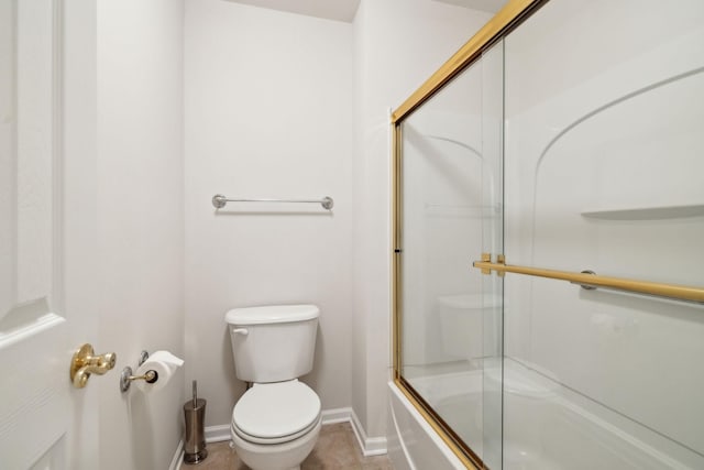 full bathroom featuring bath / shower combo with glass door, toilet, and baseboards