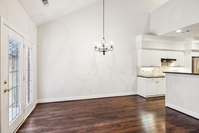 kitchen featuring dark countertops, under cabinet range hood, white cabinetry, and visible vents