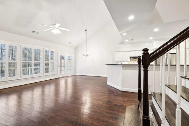 unfurnished living room with visible vents, dark wood finished floors, baseboards, and stairs