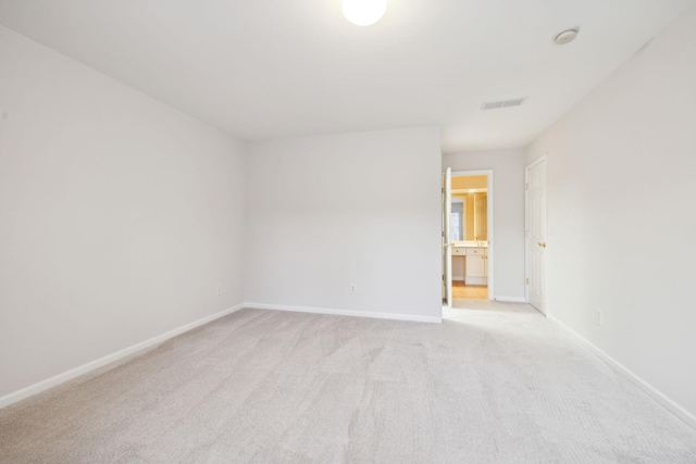 empty room with baseboards, visible vents, and light colored carpet