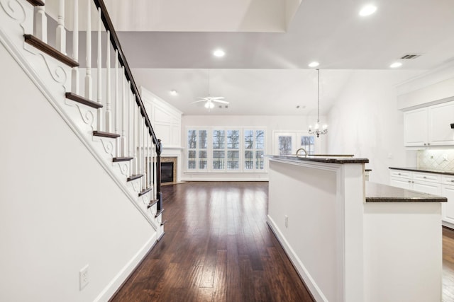 kitchen featuring dark wood-style floors, a kitchen island, white cabinetry, and decorative backsplash