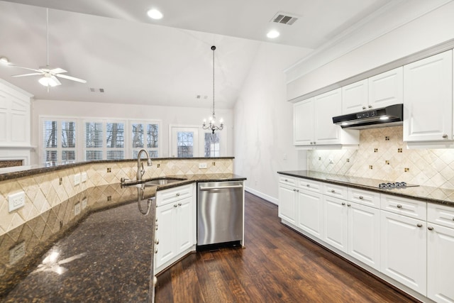 kitchen with under cabinet range hood, a sink, white cabinetry, stainless steel dishwasher, and dark stone counters